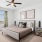 A bedroom with a ceiling fan and large window offering a scenic view